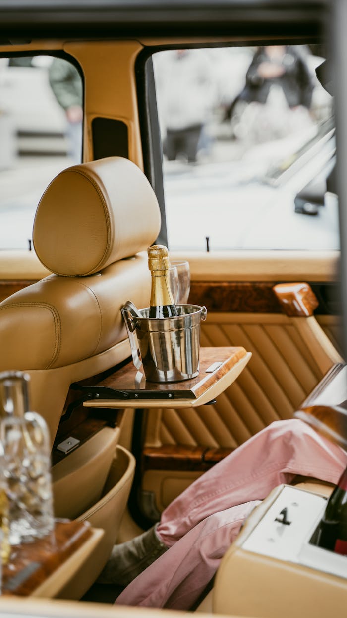 Exquisite car interior featuring champagne in a bucket, epitome of luxury and sophistication.